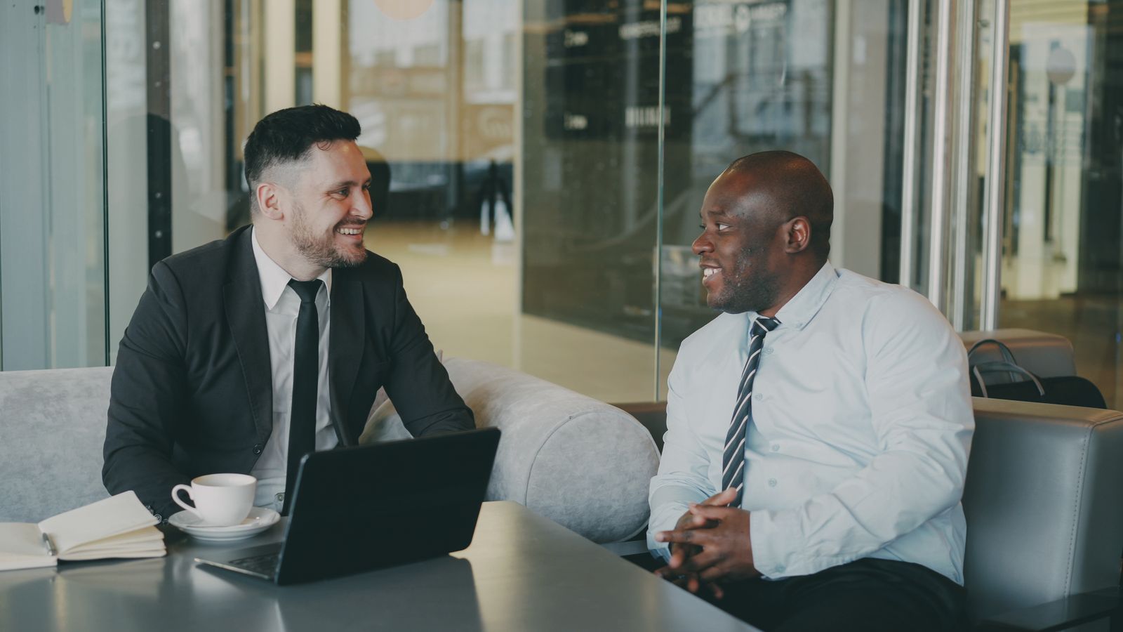Twee zakelijke professionals in gesprek in een modern kantoor
