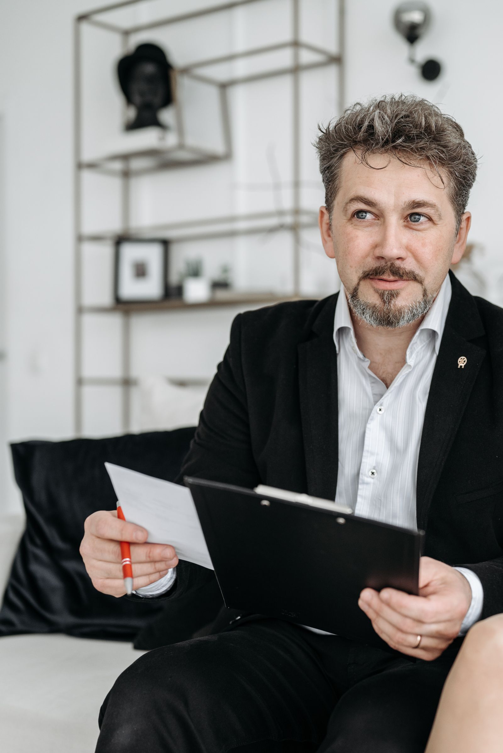 Ondernemer in een zwart pak met documenten op een klembord